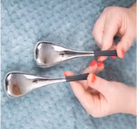 hands holding massage equipment for face and body