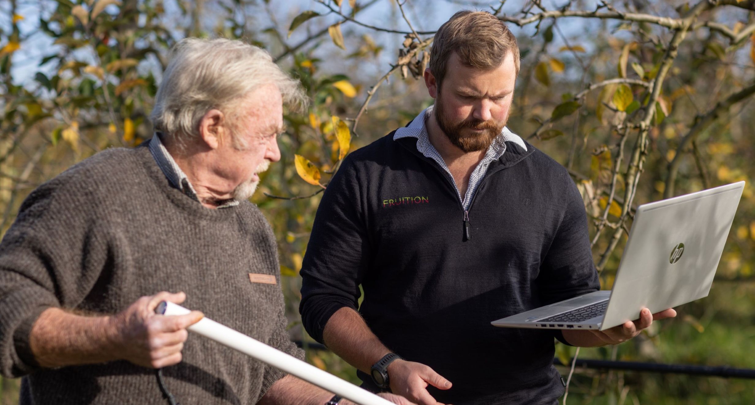 Two technicians installing a soil moisture probe in a Hawkes Bay apple orchard.
