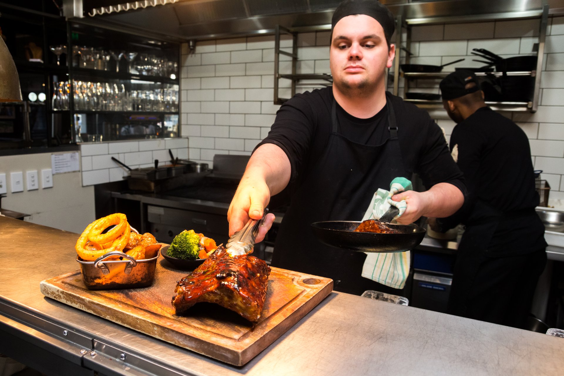 Chef plating a dish in a busy kitchen