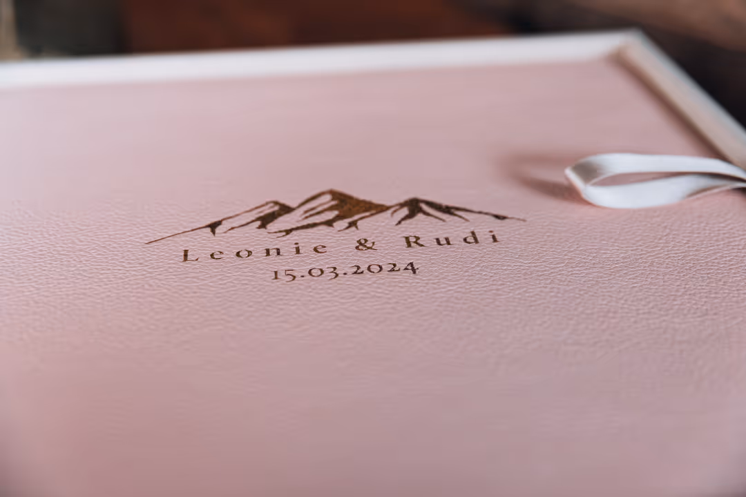 Het Grote Album - Echt leer (Rozenkwarts) met een gouden embossing in een eigen ontwerp. De doos is de kleur Nevel.