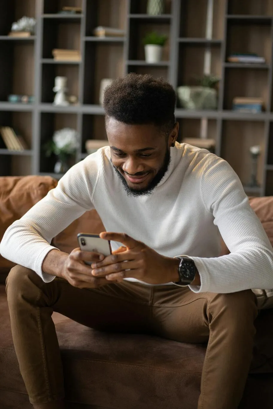 Homme assis dans un fauteuil, sur son smartphone