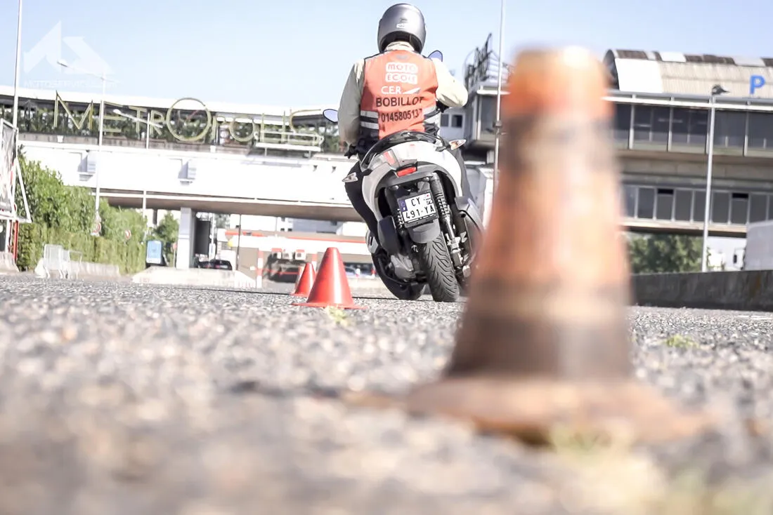 une femme montre son permis en souriant en étant sur un scooter