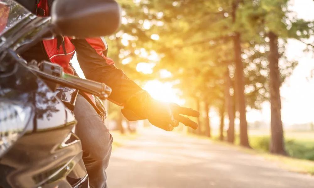 Un motard faisant un signe de la main sur sa moto