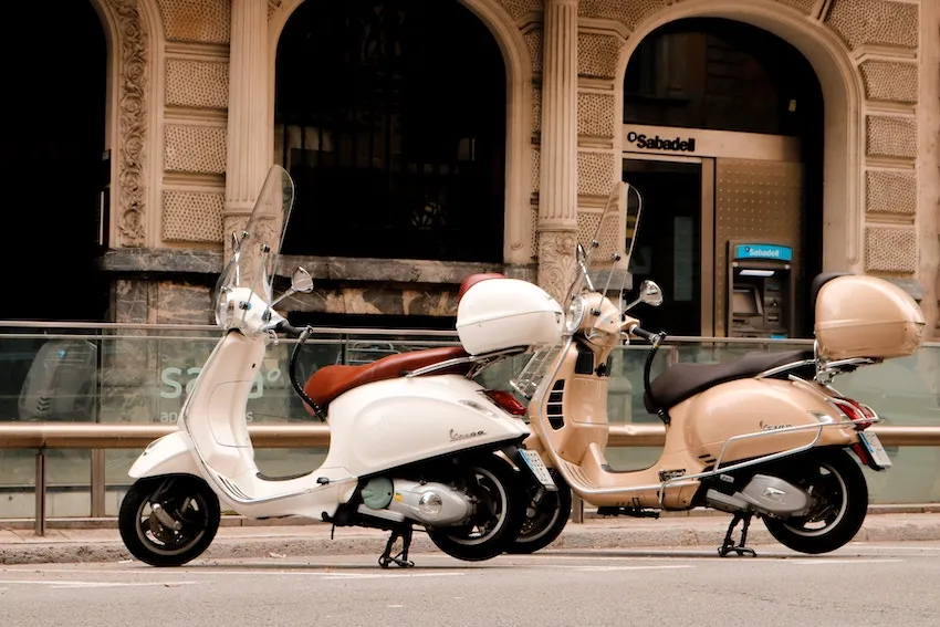 Deux scooters beige et blanc stationnées côte à côte