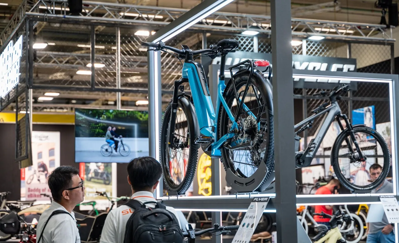 Des hommes en train de regarder un stand d'exposition à l'Eurobike 2023
