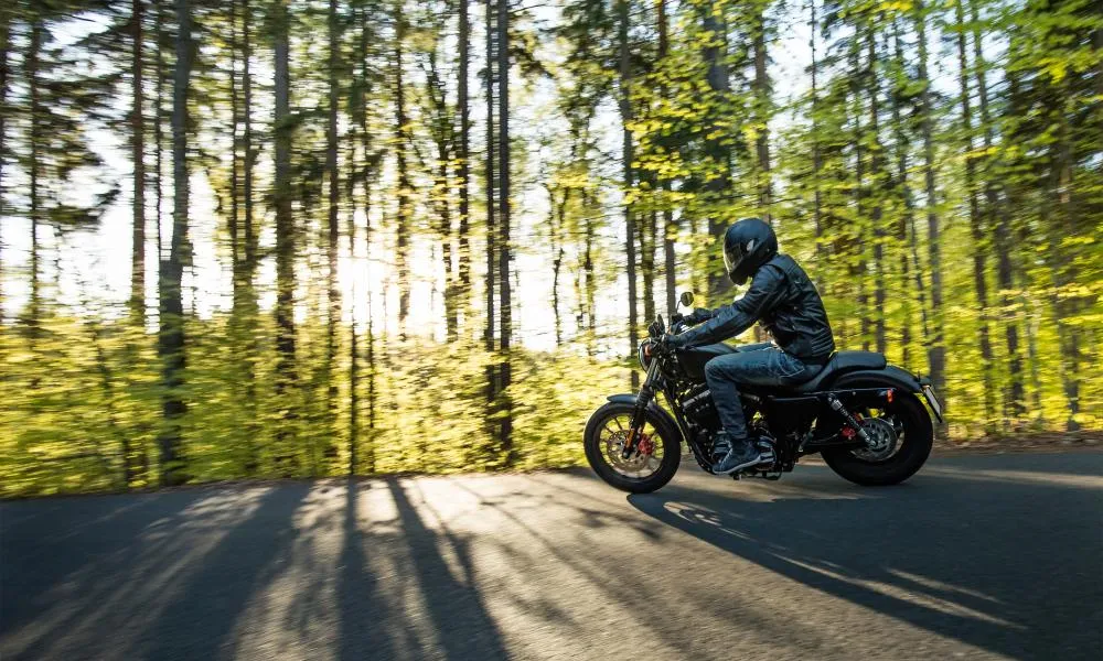 Un homme qui roule à bord de sa moto dans la rue.