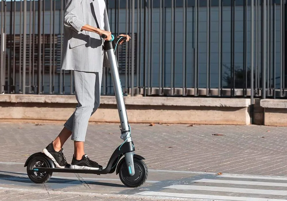 Un jeune homme qui conduit la trottinette électrique Cecotec Bongo A-Series dans la rue