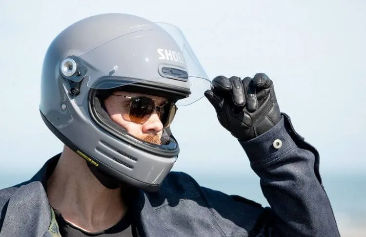 Un homme qui porte un casque intégral et qui soulève la visière 