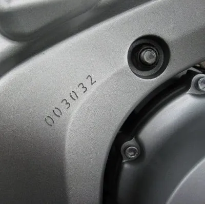 Une pièce de moto qui a été gravé avec un numéro. 