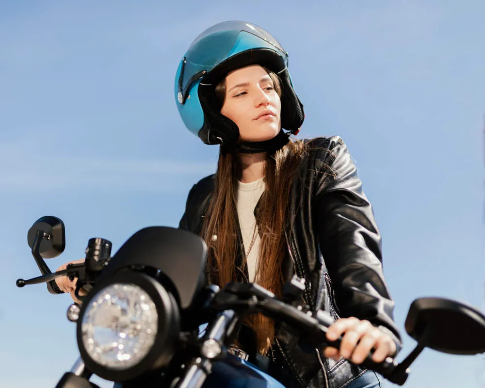 Une femme sur une moto portant un casque bleu. 