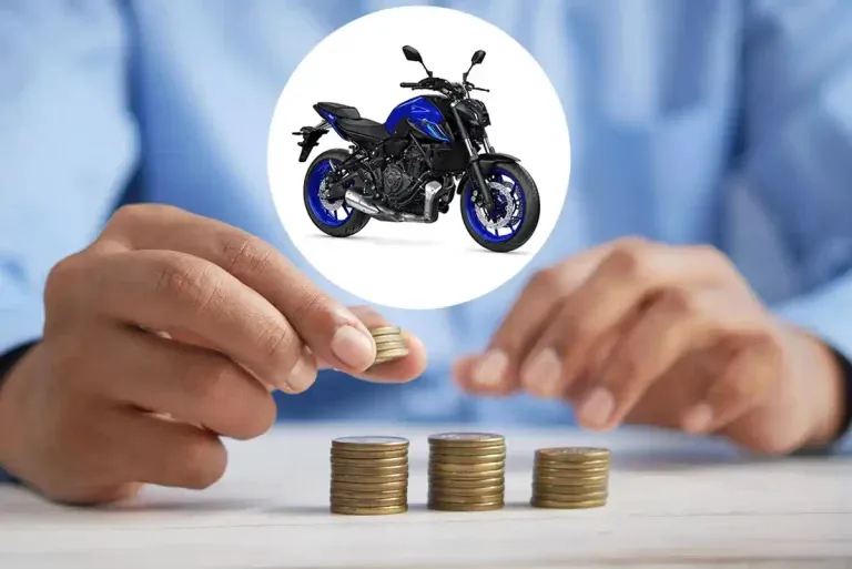 Une main qui dépose des rangées de pièce sur une table avec la photo d'une moto sur le dessus. 