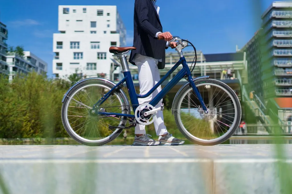 Un vélo électrique Bellecour de Voltaire tenu par un homme en balade dans la rue
