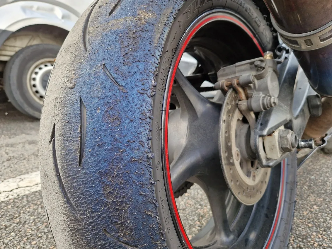 Un pneu de moto très usé avec des craquelures.