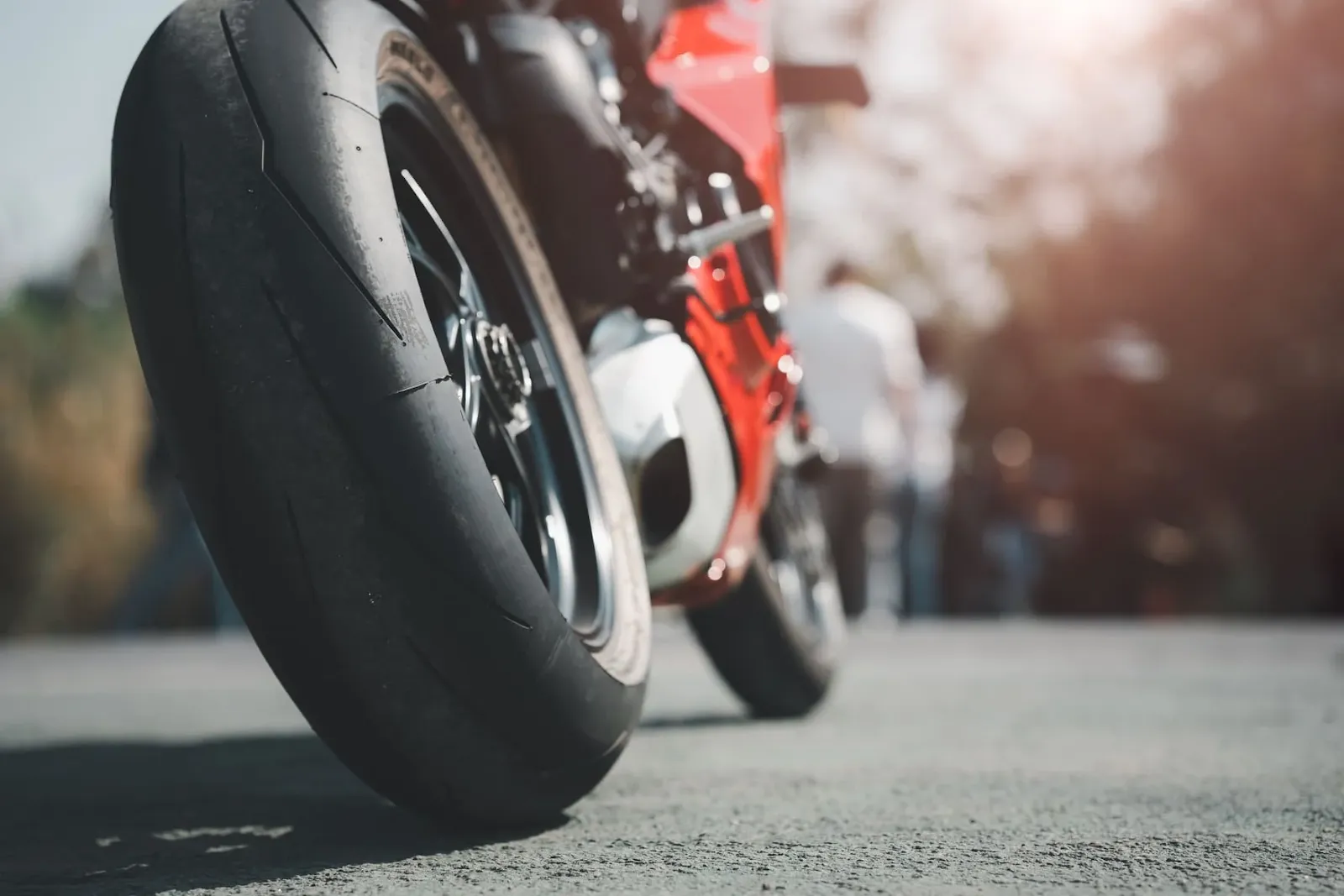 Une moto garée sur la route avec le pneu arrière mise en évidence.