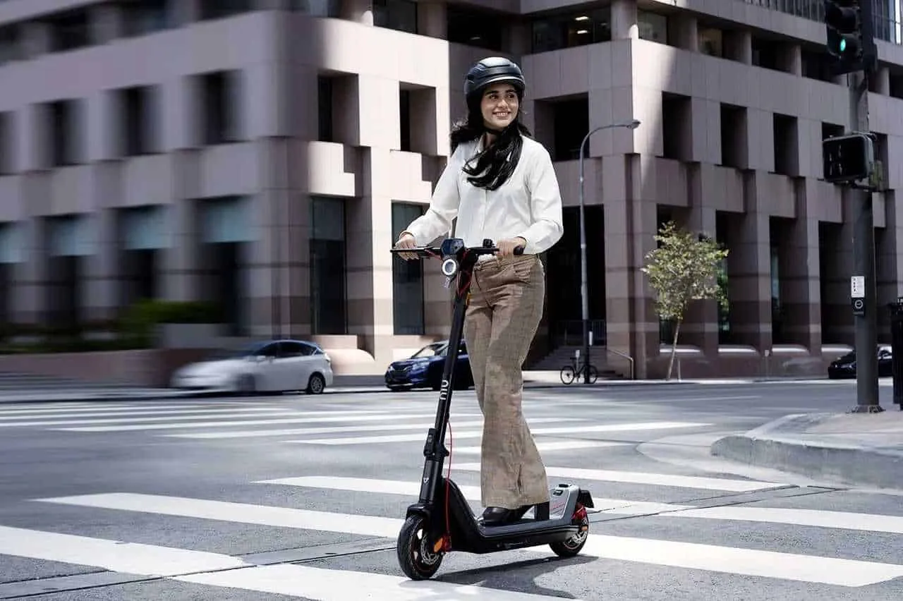 Une femme qui conduit un NIU KQi3 Max dans la rue.