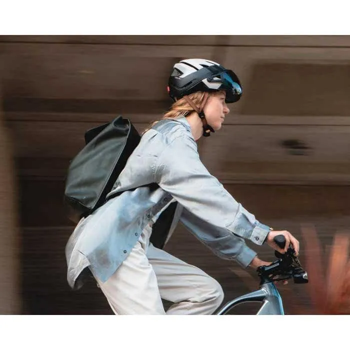 Une femme qui conduit son vélo dans la rue avec le casque Julbo Itinéraire Evo