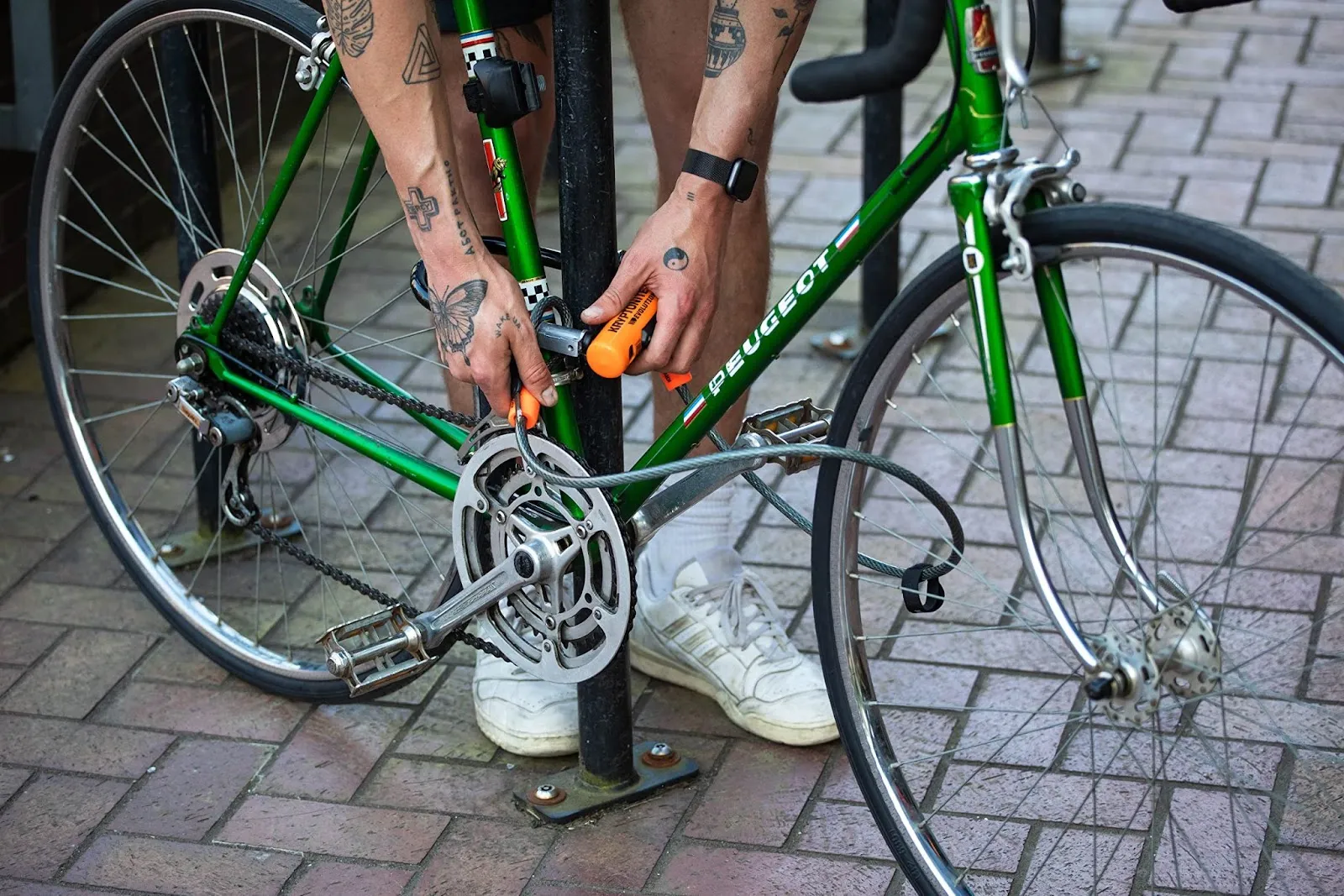 Un homme en train d'attacher son vélo avec le cadenas Kryptonite Evolution Mini-7