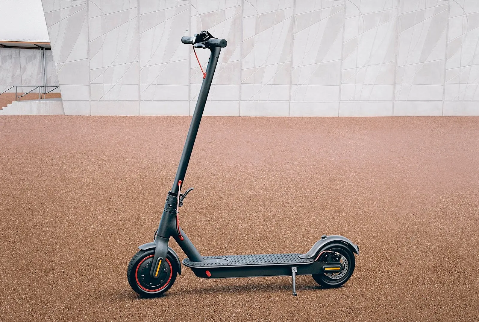 Une trottinette électrique Xiaomi Mi Electric Scooter Pro 4 garé devant un immeuble.