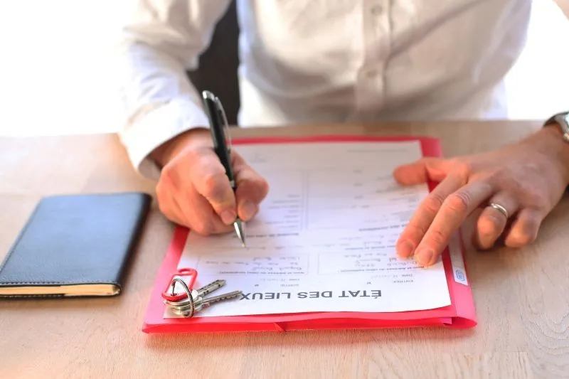Un homme entrain de remplir le document de l'état des lieux