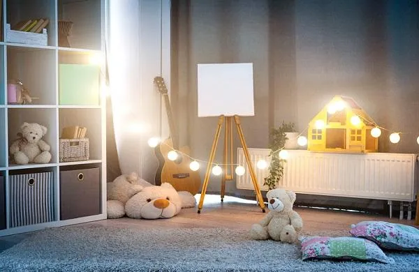 Une chambre de bébé avec une guirlande et un lampadaire d'intérieur comme éclairage.