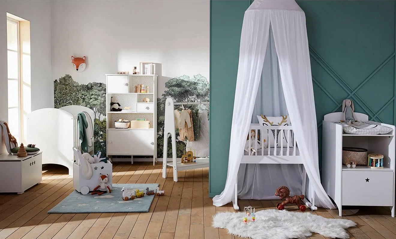 Une chambre de bébé stylée avec des couleurs bleu canard et blanc.