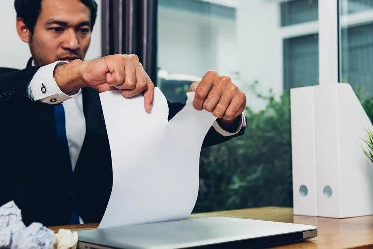 Un homme qui déchire un document.