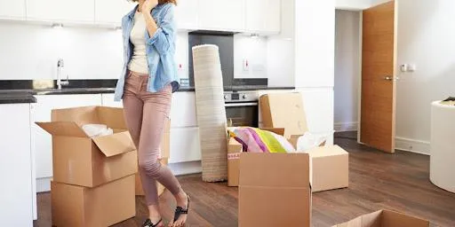 Une femme au milieu de ses cartons dans sa cuisine