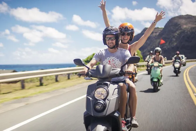 Un couple qui conduit un scooter sur une route.