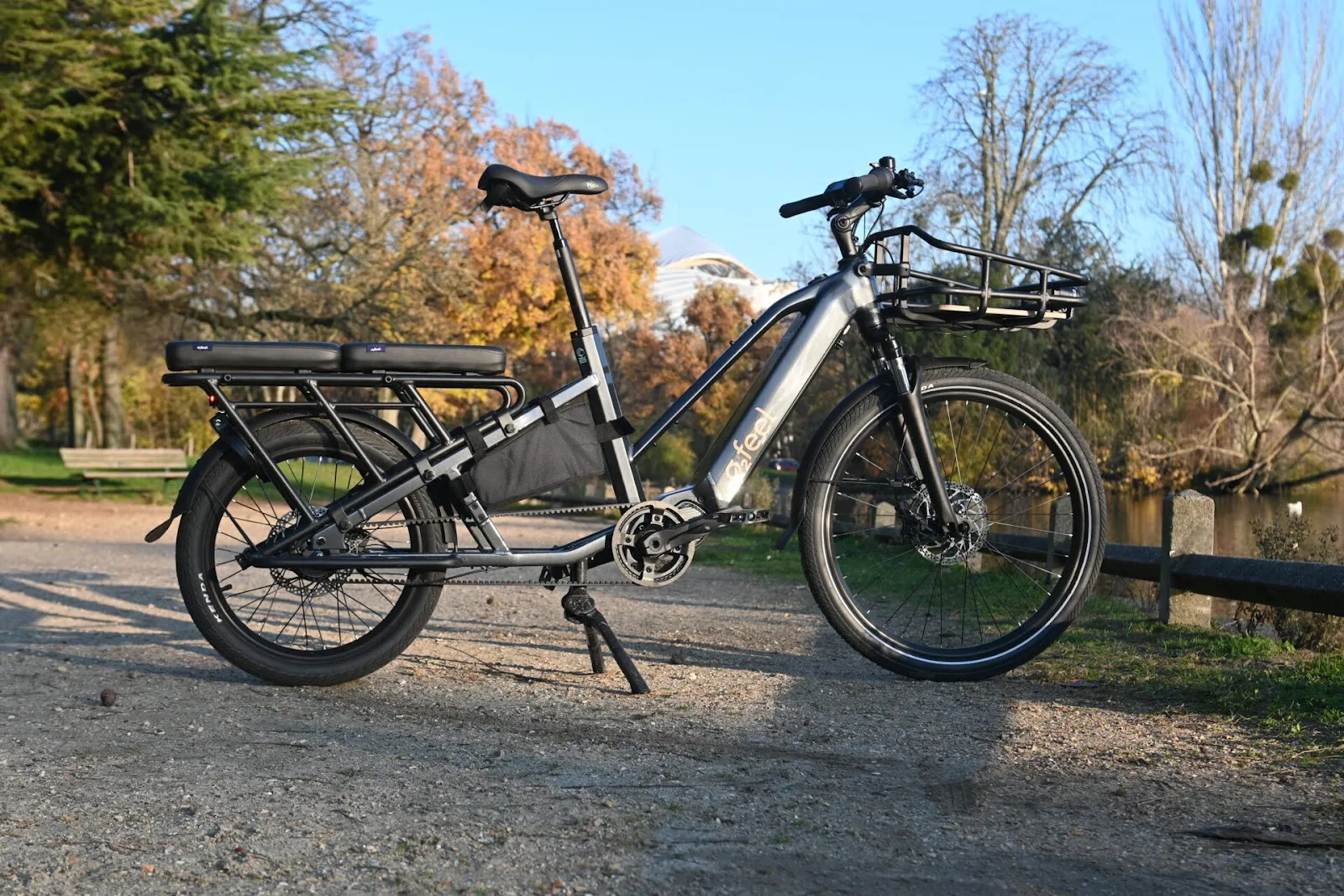 Un vélo longtail noir garé dans un parc.