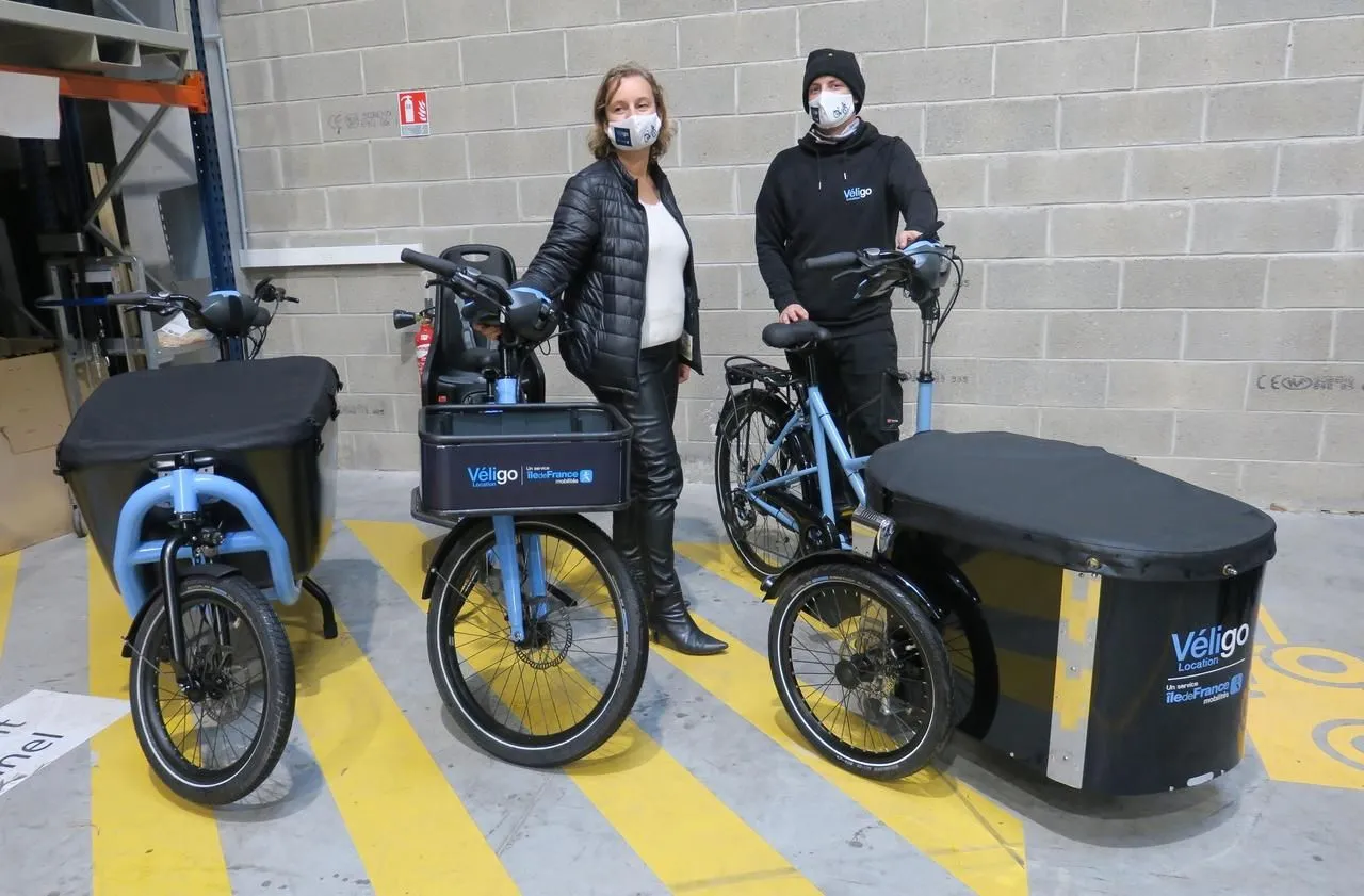Trois modèles de vélo Véligo devant un couple