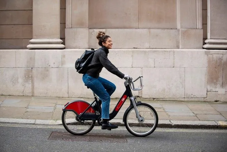 Une femme qui roule dans la rue à bord d'un vélo électrique.