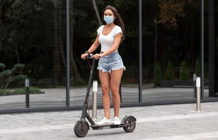 Un jeune fille qui roule sur une trottinette électrique