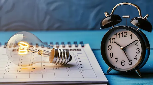 Une ampoule et un réveil avec un calendrier en dessous.