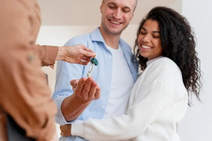 Un couple qui reçoit une clé de la part d'un homme
