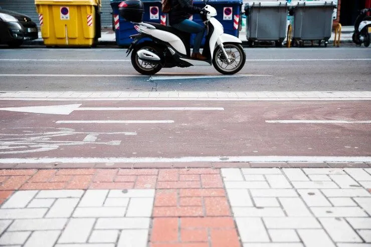 Une moto qui roule dans la rue conduite par une femme