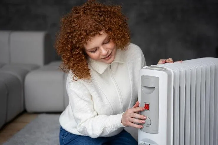 Une femme qui appuie sur des boutons d'un radiateur