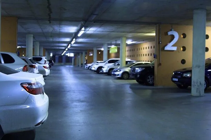 Photo d'un parking sombre avec plusieurs voitures garées