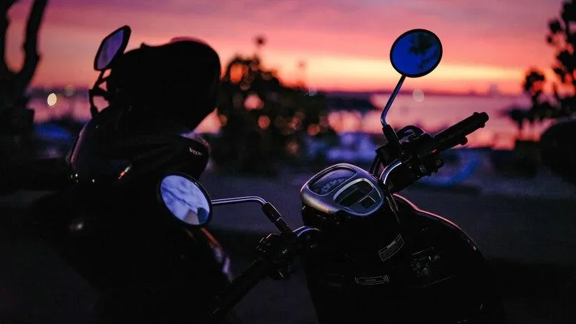 Un vélo garé face à une coucher de soleil.