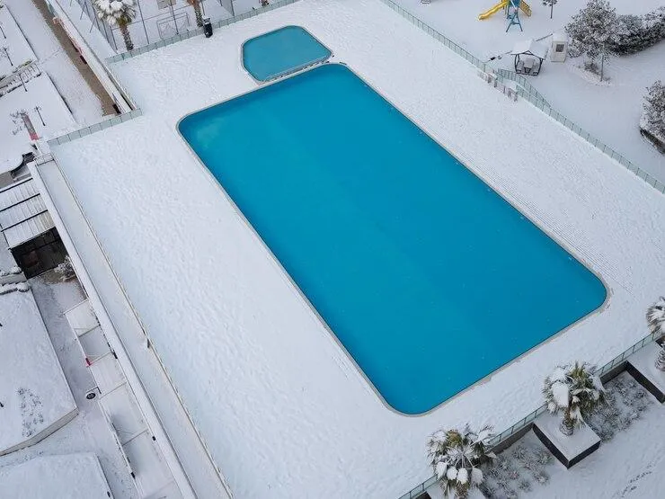 Une piscine couverte par une bâche bleue