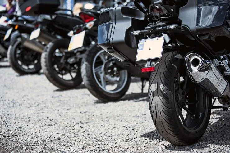 Une photo de plusieurs scooter et moto avec un gros plan sur les roues arrières