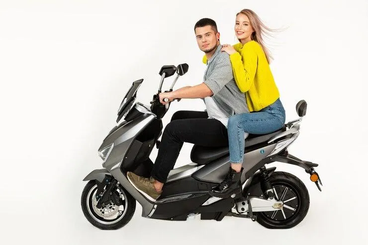 Un couple qui roule sur un scooter sur fond blanche