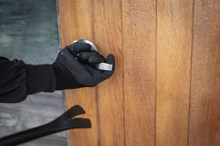 Une personne portant des gants noir et une barre qui ouvre une porte