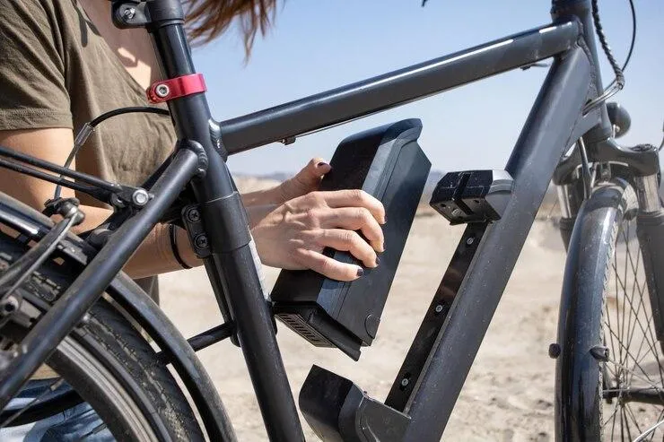 Une personne qui retire la batterie d'un vélo