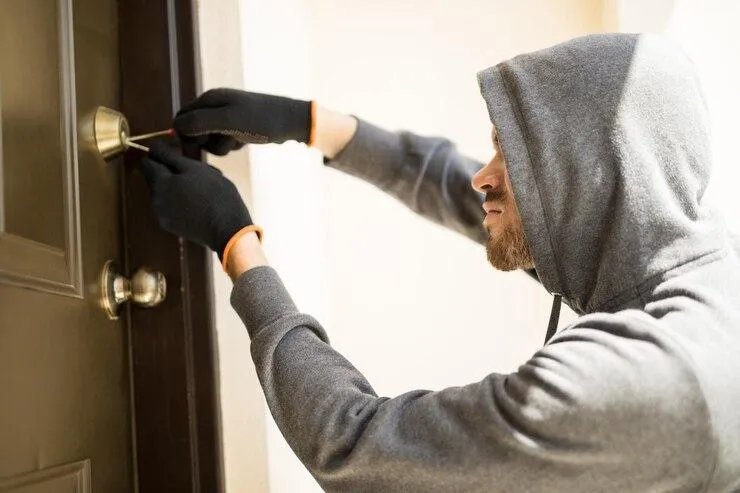 Un homme qui force la serrure d'une porte
