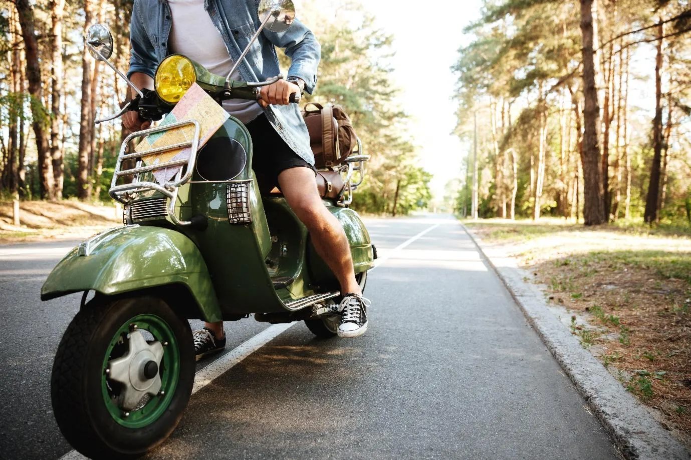 Un homme sur un scooter vert sur la route