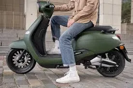 Un hommesur le scooter Brumaire vert