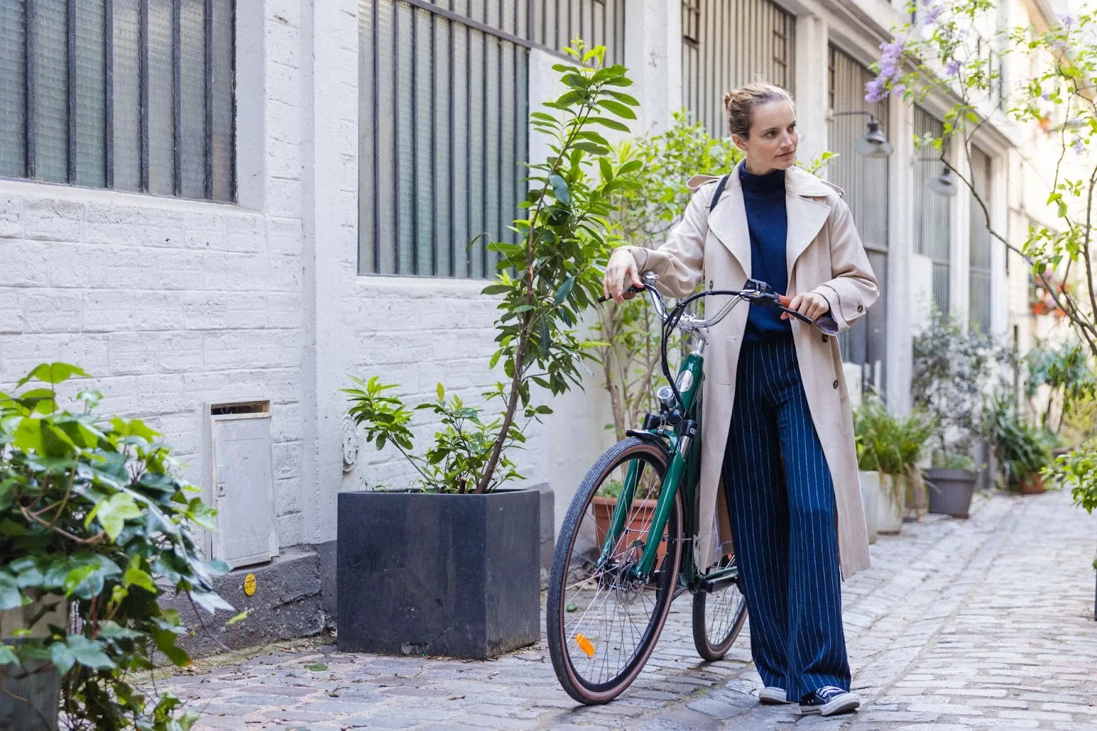 Une femme qui pousse un vélo de ville électrique vert