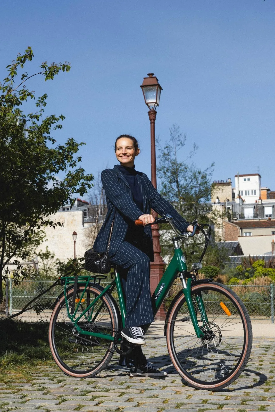 Une femme dans un parc qui se tient sur un vélo avec un pied sur le sol