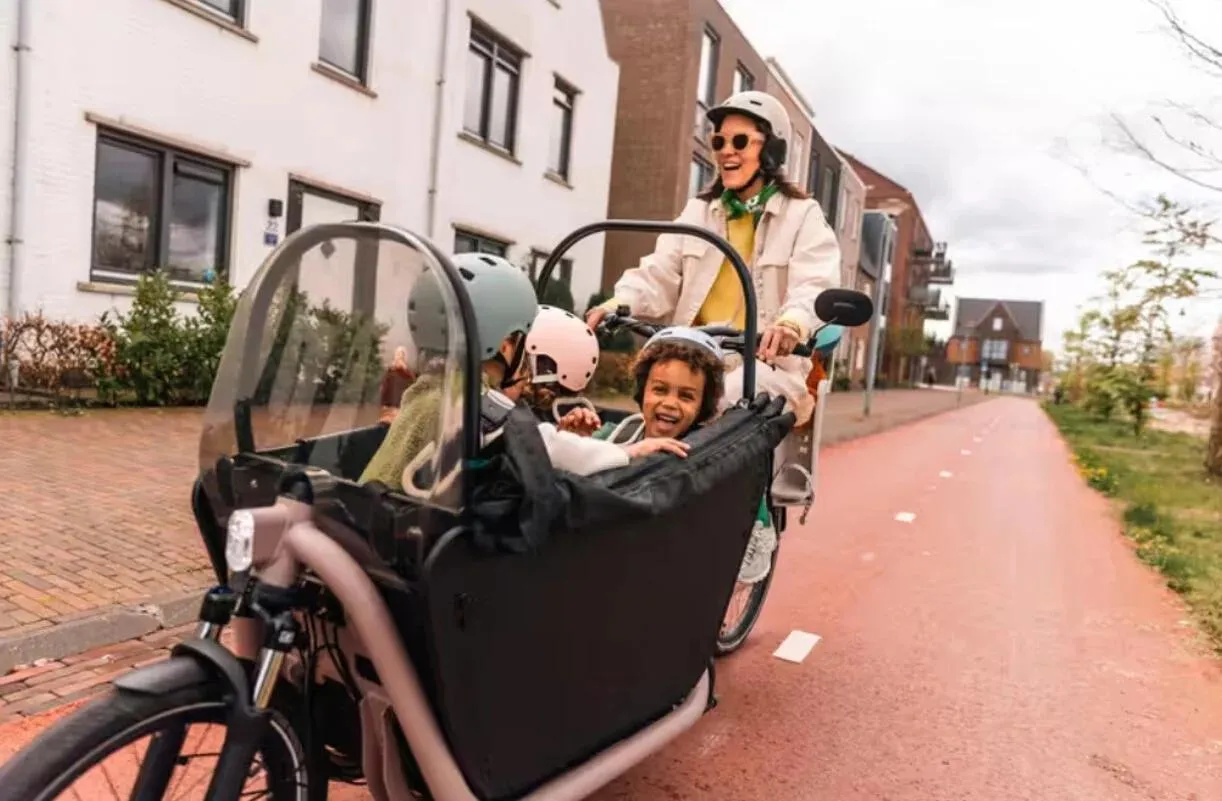 Une femme sur un vélo Btwin avec des enfants sur la route