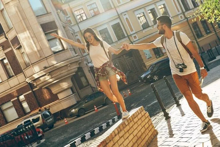 Un couple qui se tient la main en se promenant dans les rues d'une ville